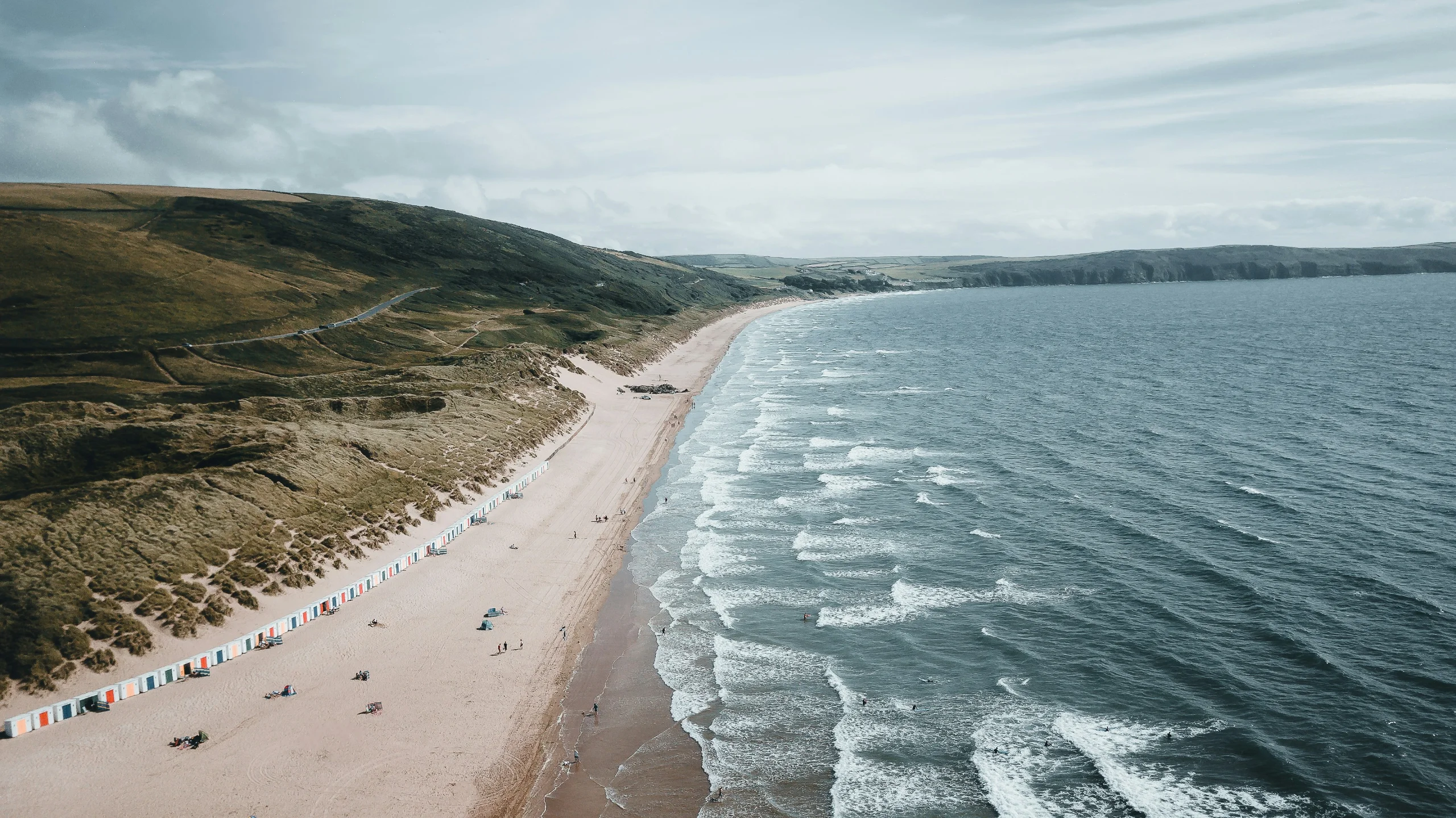 Woolacombe's three-mile sandy beach in North Devon, stretching along the bay below green headland