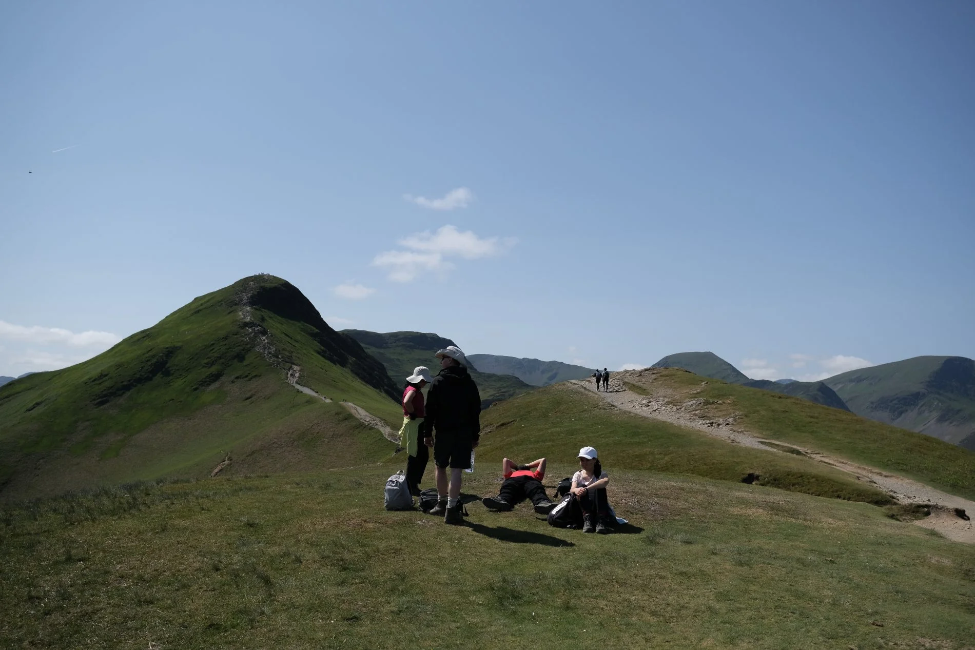 Walkers on the summit ridge of Catbells in the Lake District, with Derwentwater and Keswick below