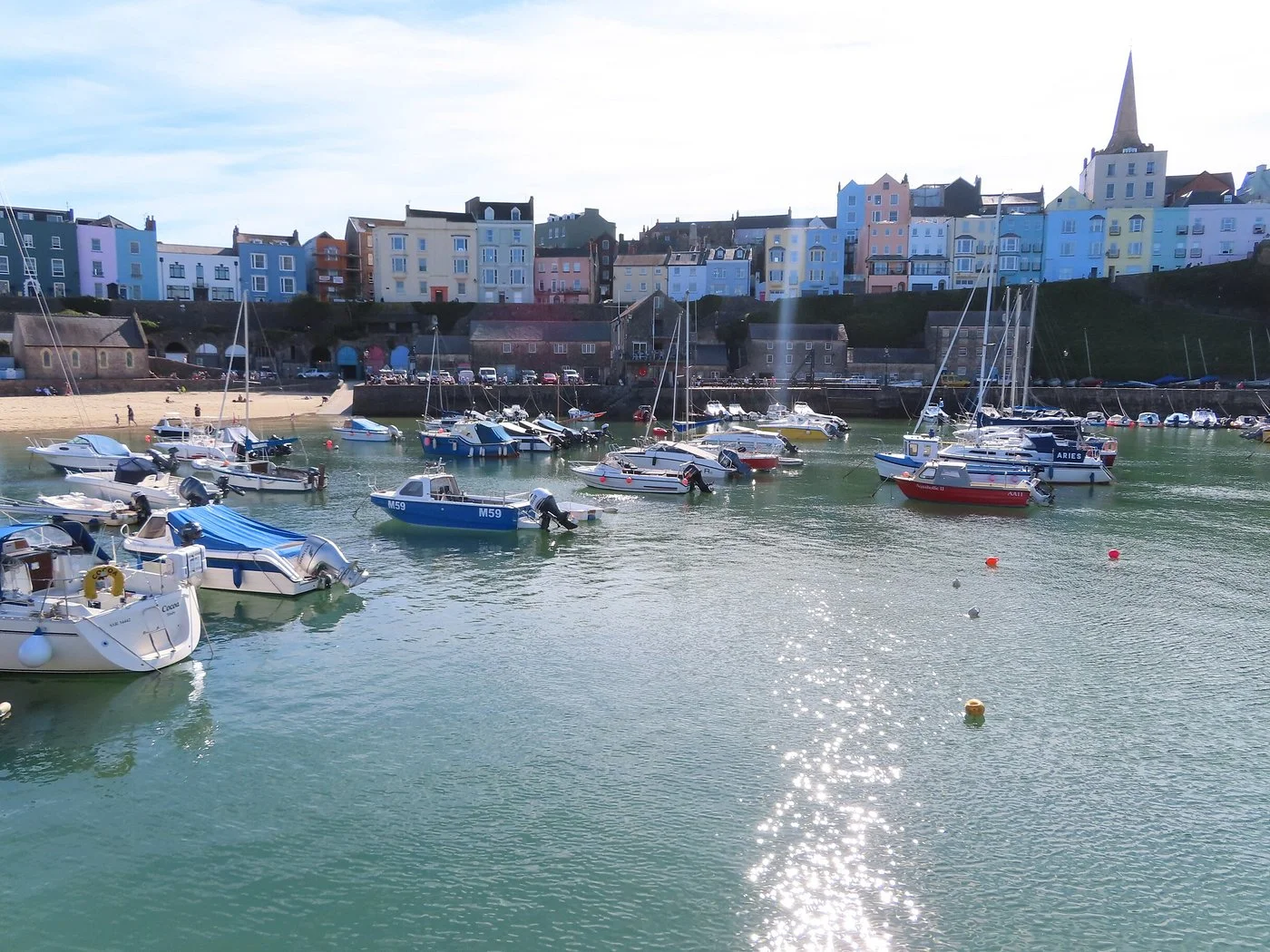 Colourful pastel houses above Tenby harbour and its sandy beach in Pembrokeshire