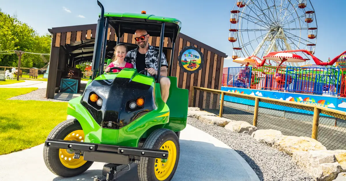 A tractor ride at Folly Farm in Pembrokeshire, with a big wheel fairground ride in the background