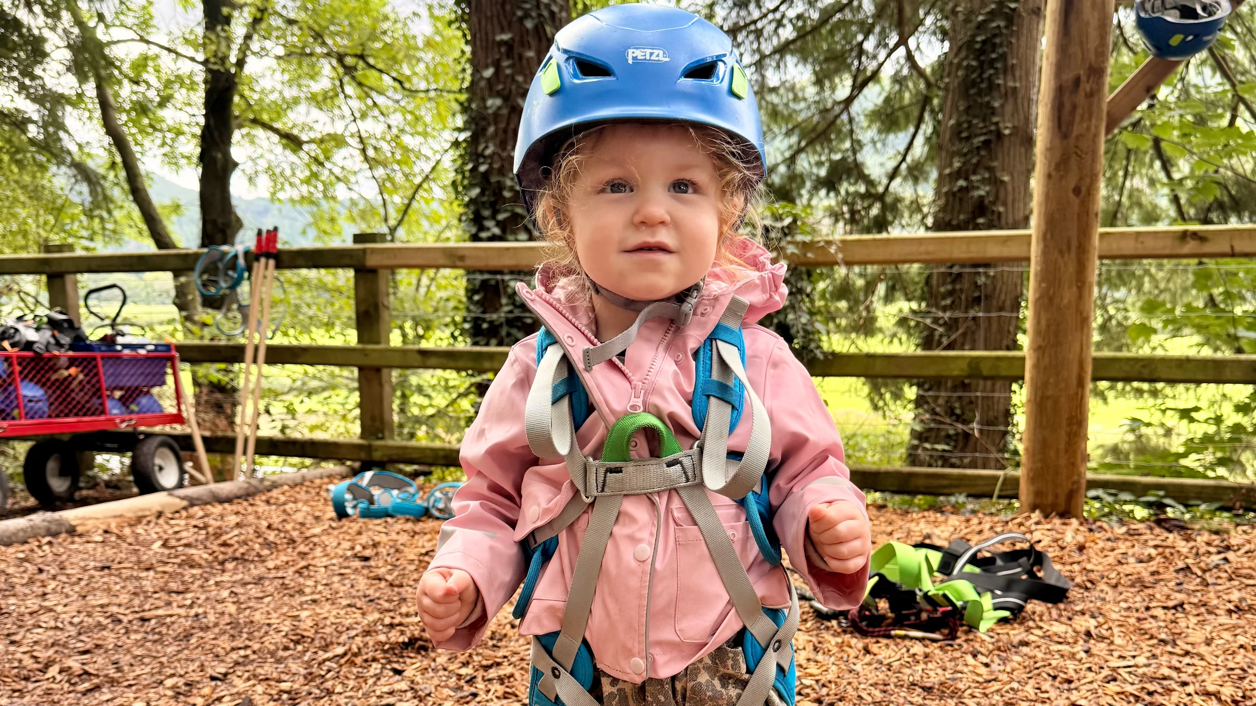 A young girl in a safety harness at Zip World Betws-y-Coed in Snowdonia, North Wales