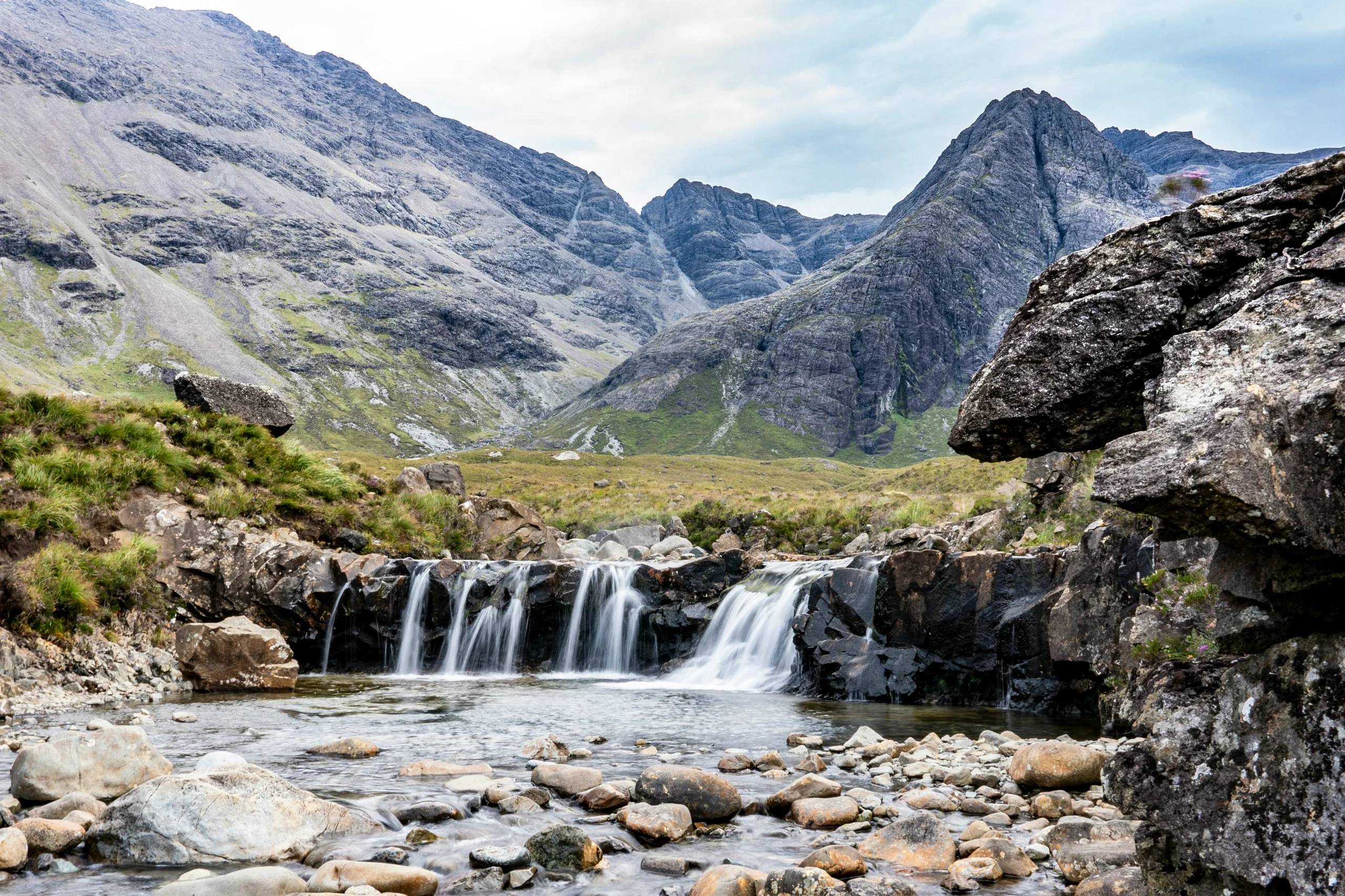 The clear blue Fairy Pools and waterfalls in Glenbrittle on the Isle of Skye, with the Cuillin mountains behind