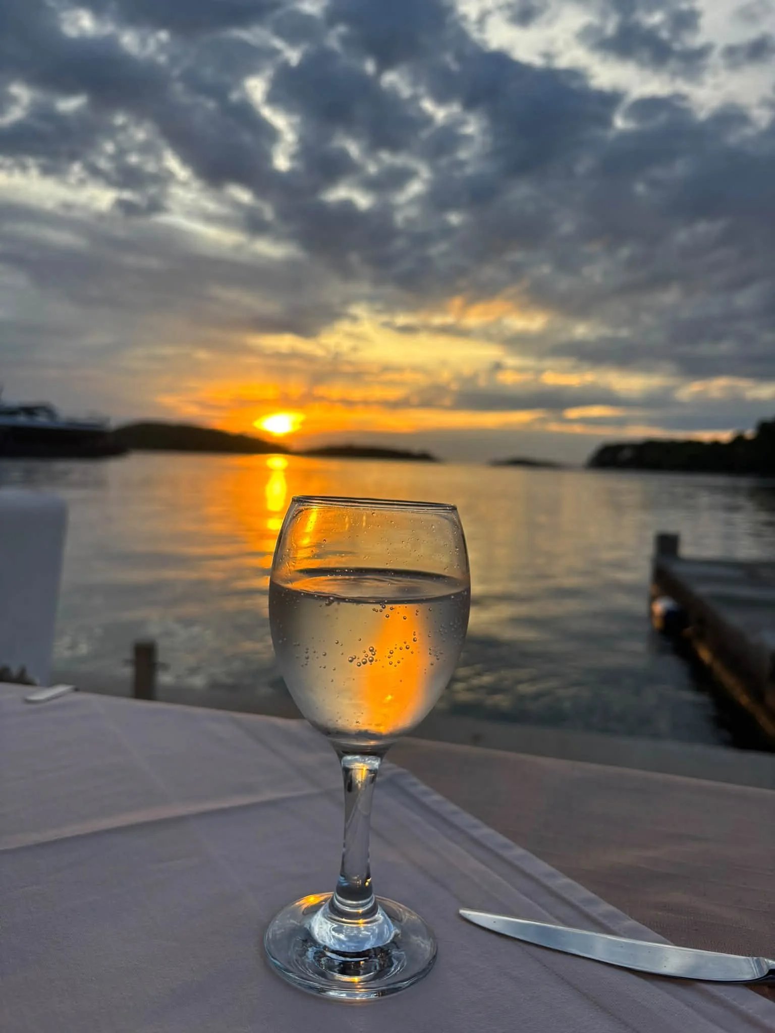 A glass of wine by the water at sunset in Polače