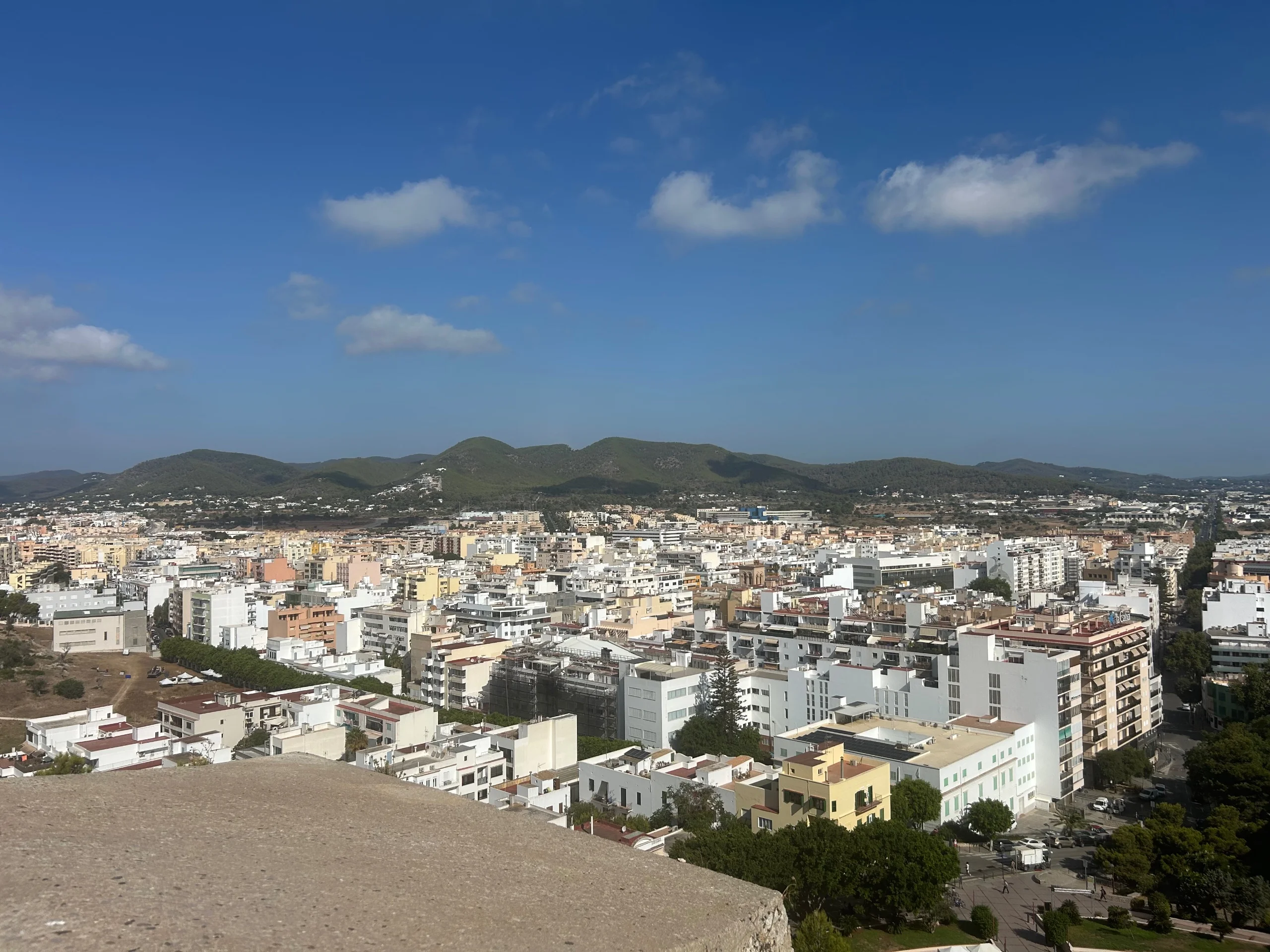 View over the rooftops of Ibiza town from the castle walls, with hills behind